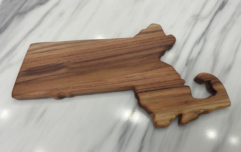 Custom Massachusetts state-shaped teak wood charcuterie boardr showing the wood's striking natural wood grain.