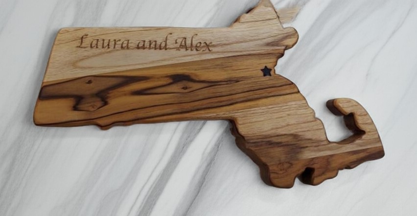 Custom Massachusetts state-shaped teak wood board with "Laura and Alex" name engraving and a laser-etched star.