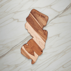 Custom New Jersey state-shaped teak wood board with "Jersey Girl" laser engraving and natural two-tone wood grain.