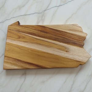 Pennsylvania state-shaped teak wood charcuterie board with a dramatic dark natural wood grain streaks.