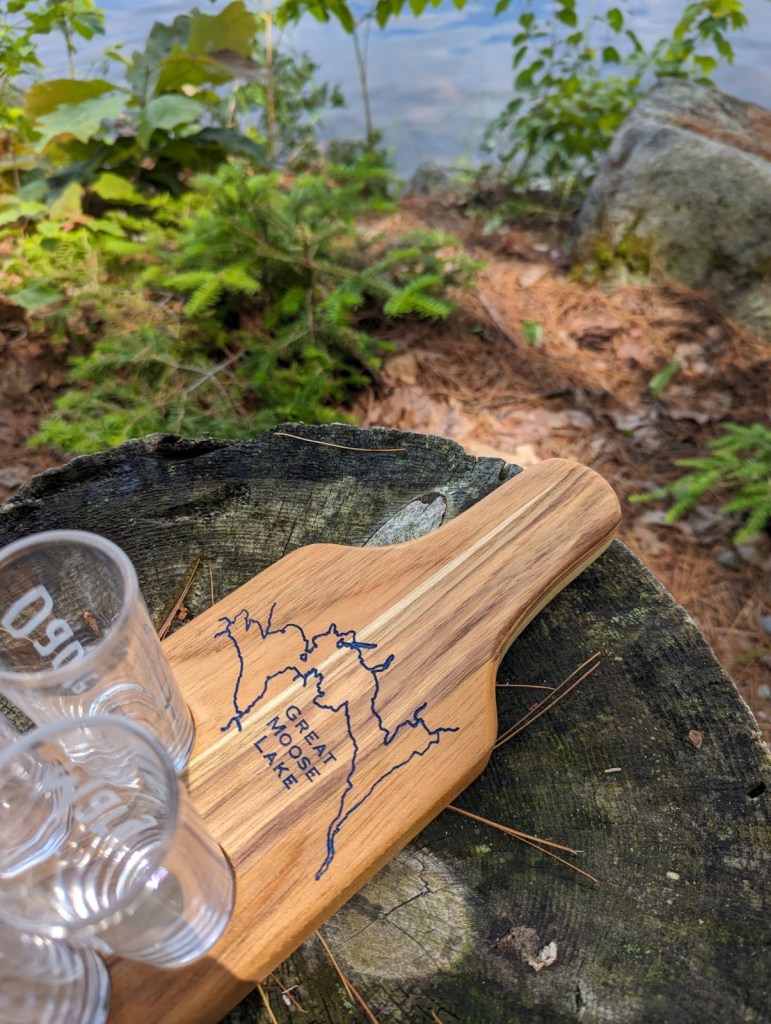 Custom teak shot flight board with handcrafted map engraving and glass cutouts.